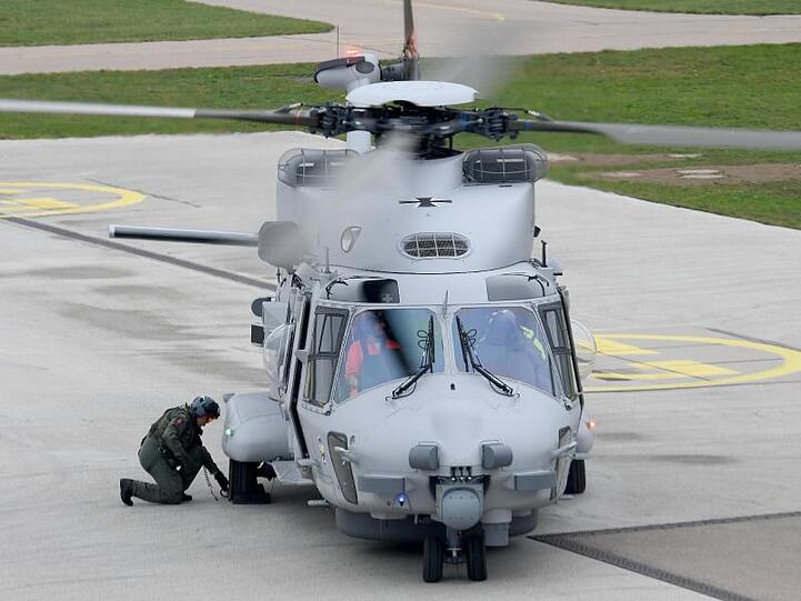 Ein Bordtechniker befestigt an einem gelandeten Hubschrauber Bremsschuhe. Foto: Stefan Puchner/dpa