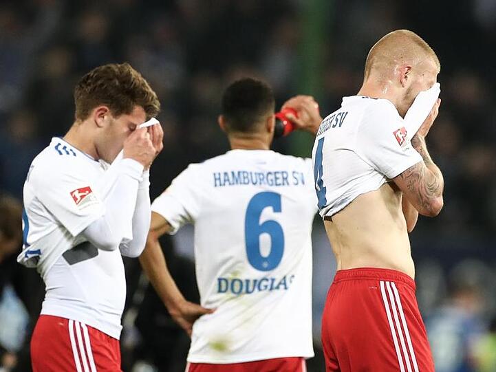 Mats Köhlert (l-r), Douglas Santos und Rick van Drongelen sind fassungslos: Der HSV hat daheim gegen Magdeburg mit 1:2 verloren.