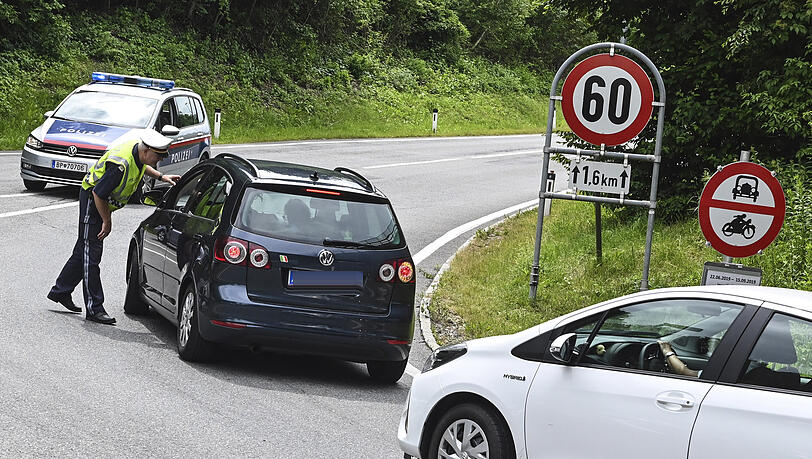 Ein Polizist h&auml;lt Autos auf einer Stra&szlig;e an.