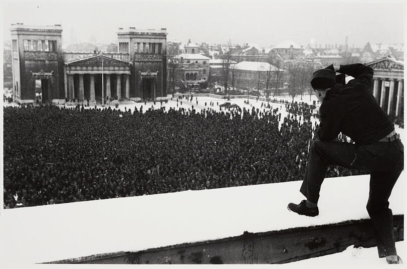 Dieser GI fotografiert vom Dach des ehemaligen Verwaltungsbaus der NSDAP auf eine große Demonstration im Winter 1945/46.