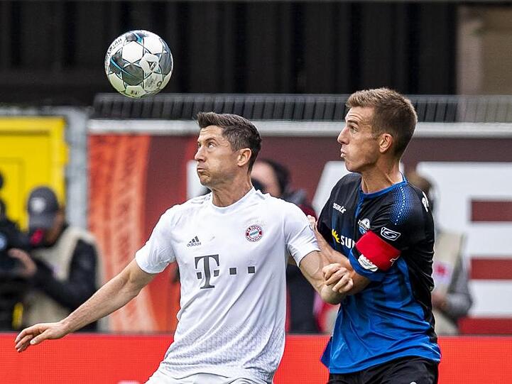 Münchens Robert Lewandowski und Paderborns Uwe Hünemeier (l-r.) im Zweikampf um den Ball. Foto: David Inderlied