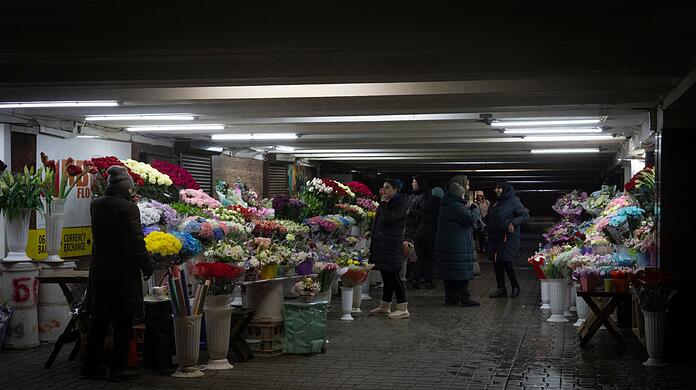 Blumenverkäufer unterhalten sich in einem unterirdischen Durchgang im Stadtzentrum von Kiew.