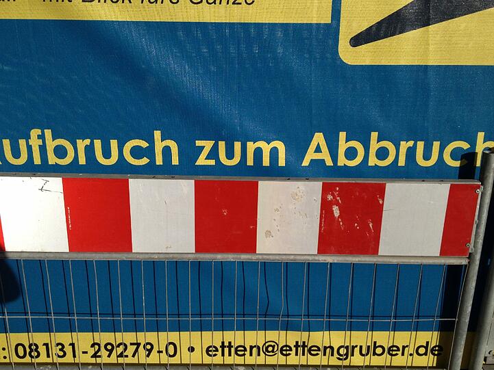 Vom "Blick aufs Ganze" - wie es das Abbruchunternehmen auf seinem Transparent verspricht - werden die alteingesessenen Bewohner der Häuser hinter den Glockenbachsuiten in Zukunft wohl nur träumen können....