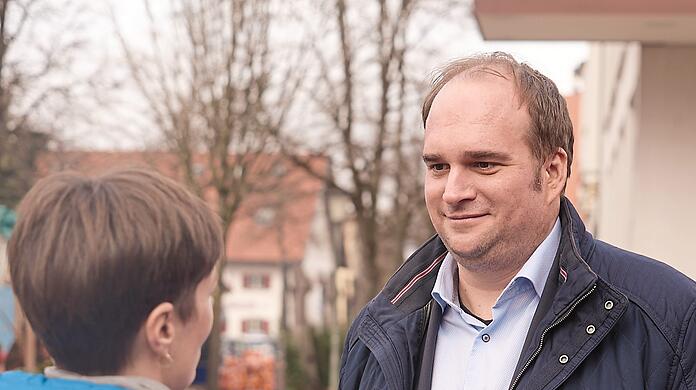 Auf einem Wochenmarkt in Großhadern verteilt der SPD-Kandidat Sebastian Roloff Flyer. Eigentlich lebt er in Giesing. Doch sein Wahlkreis, der Münchner Süden, ist groß und vielfältig.