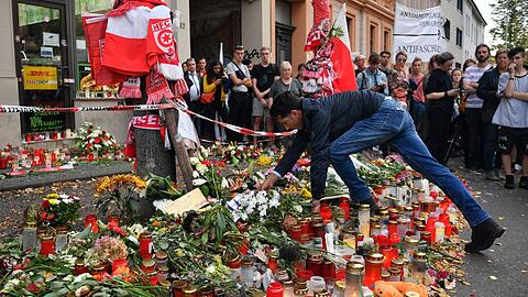 Gedenken in Halle: Ein Mitarbeiter des Döner-Imbisses, vor dem ein Mann erschossen worden ist, legt einen Blumenkranz nieder.