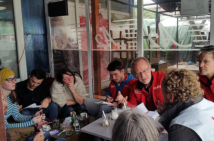 Täglich um 15 Uhr trifft sich das &bdquo;humedica&ldquo;-Team mit Vertretern anderer Organisationen und den Freiwilligen, die sich in Presevo engagieren. Ganz rechts: Mediziner Markus Hohlweck.