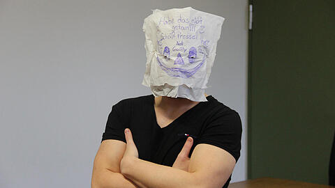 Der Angeklagte Cem F. mit einer Maske vor Gericht.