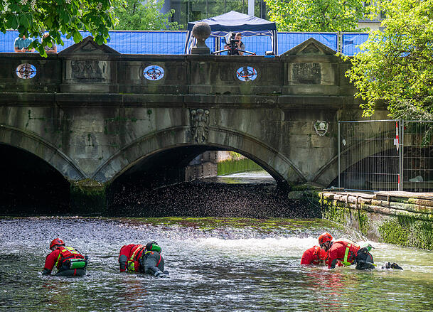 Polizeitaucher durchsuchen nach dem t&ouml;dlichen Unfall der Surferin im April 2025 den Wellenbereich im bereits abgesenkten Eisbach.