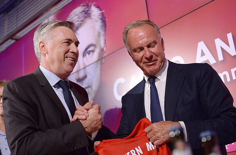 Vorstandsboss Karl-Heinz Rummenigge überreicht Ancelotti ein Bayern-Trikot.