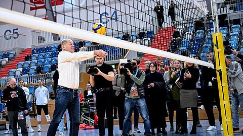 Scholz spielt Volleyball bei einem Besuch des Trainings der Volleyballerinnen des SC Potsdam.