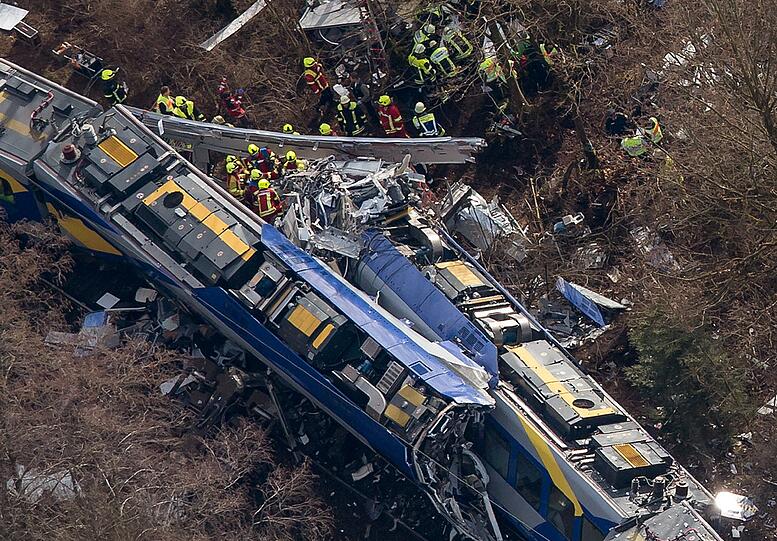 ARCHIV - Rettungskräfte stehen am 09.02.2016 an der Unfallstelle eines Zugunglücks in der Nähe von Bad Aibling (Bayern). Am 07.10.2016 findet die Einweihung der Gedenkstätte für das Zugunglück in Bad Aibling statt.