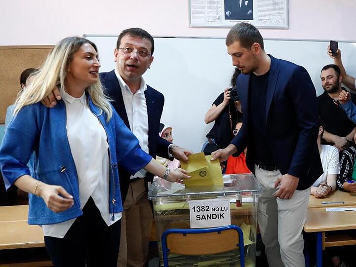 Ekrem Imamoglu (M) mit seiner Frau Dilek (l) und seinem Sohn bei der Stimmabgabe.