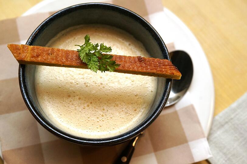 2. GANG - Quitten-Apfelrahmsuppe mit Gewürzbiskuit
Ein fruchtiges, stimmiges Süppchen mit einem Biskuit, in dem unter anderem Lorbeer, Anis, Nelke und Piment die Geschmacksknospen aktivieren. Der schöne Schmelz des trockenen Silvaners &bdquo;Retzstadt&ldquo;, Jahrgang 2013 von der Familie May rundet diesen Gang ab.