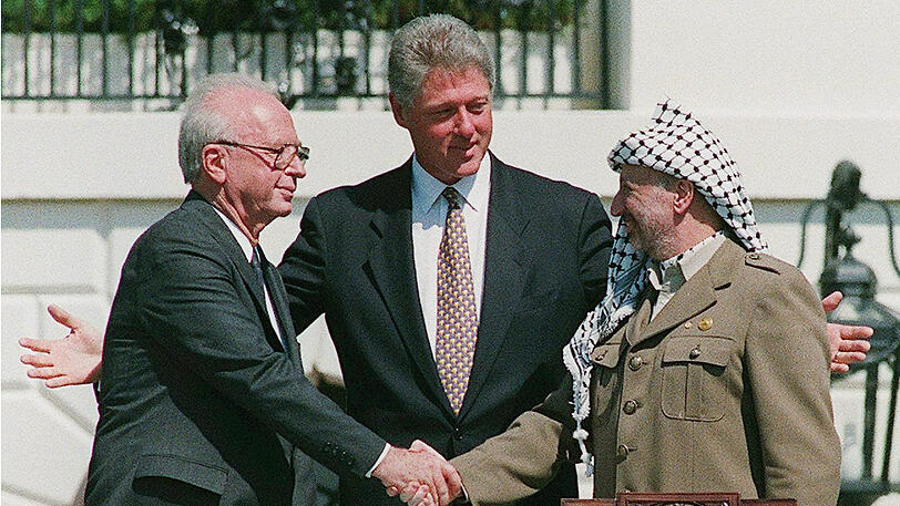 13. September 1993: Israels Ministerpräsident Jitzhak Rabin (l.) und Palästinenserpräsident Jassir Arafat (r.) im Rosengarten des Weißen Hauses. Ihr Handschlag besiegelt das Nahost-Friedensabkommen von Oslo. US-Präsident Bill Clinton steht als Pate dahinter.