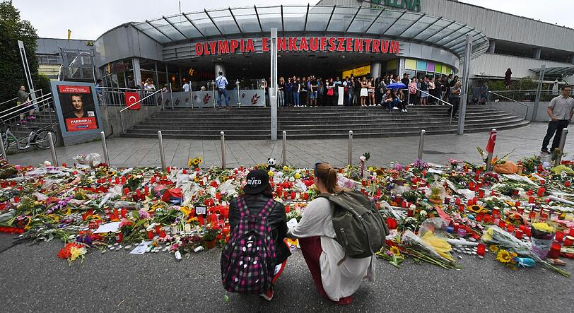 Anteilnahme vor dem OEZ: Am Montag nach der Schießerei trauern Münchner vor dem Einkaufszentrum und gedenken mit Bildern, Blumen und Schildern.