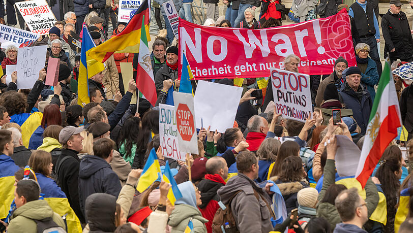 Mit Plakaten und Fahnen nehmen Demonstranten an Kundgebungen am Rande der Münchner Sicherheitskonferenz (MSC) auf dem Odeonsplatz teil.