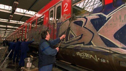 Arbeiter entfernen Graffiti an einer S-Bahn. (Archivbild)