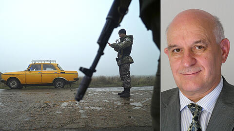 Berdyansk in der Ukraine: Ein Auto wird an einem mit ukrainischen Polizisten besetzten Kontrollpunkt angehalten. Rechts im Bild der Sicherheitsexperte Wolfgang Richter.