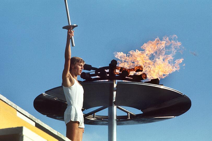 Der Schlussläufer der Fackelstafette, Günther Zahn, grüßt die im Stadion aufmarschierten Sportler, nachdem er das Olympische Feuer entzündet hat. Mit der Eröffnungsfeier im Münchener Olympiastadion wurden am 26. August 1972 die Sommerspiele eröffnet.