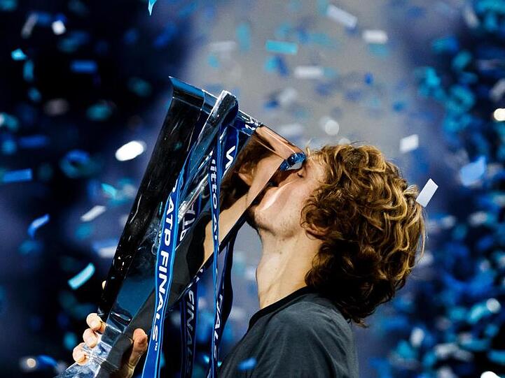 Alexander Zverev küsst im Konfettiregen von London den Pokal.