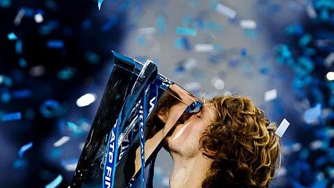 Alexander Zverev küsst im Konfettiregen von London den Pokal.