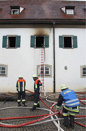 Einsatzkräfte der Feuerwehr stehen am Sonntagmorgen vor dem Franziskanerkloster in Füssen.