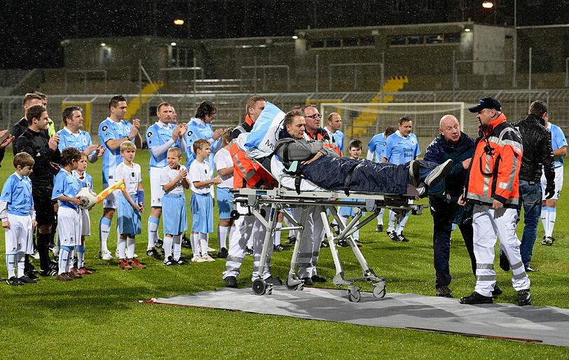 Olaf Bodden wird auf einem Krankenbett auf den Rasen des Grünwalder Stadions gefahren.