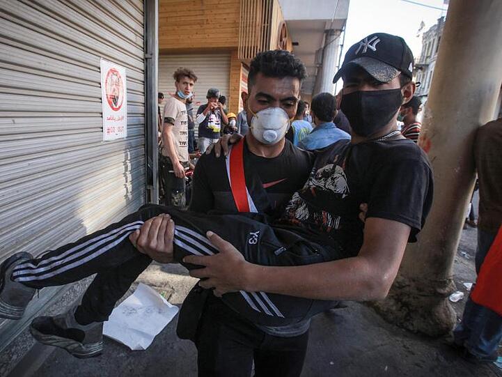 Ein verletzter Demonstrant wird bei Zusammenstößen zwischen regierungsfeindlichen Demonstranten und Bereitschaftspolizei in der Al Rasheed Straße, in der Nähe des Tahrir-Platzes weggetragen.