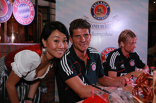 Mario Gomez hatte bei diesem PR-Termin im Paulaner Bräuhaus in Guangzhou sichtlich Spaß. Im Hintergrund schreibt Anatoliy Tymoshchuk Autogramme.