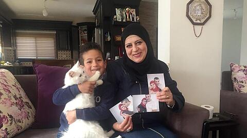 Sohn Madschd (5) und Lydia Rimawi (42) in ihrem Wohnzimmer in Rima.