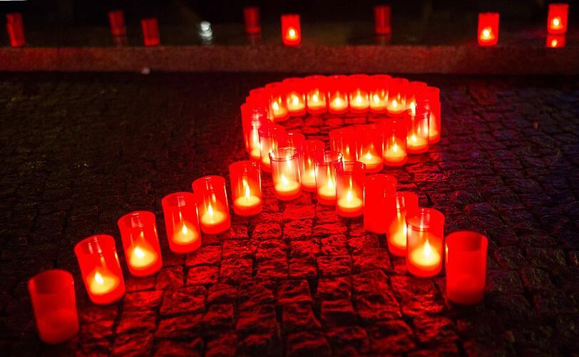 Kerzen bilden eine rote Schleife &ndash; sie ist eines der Symbole für den Kampf gegen Aids.