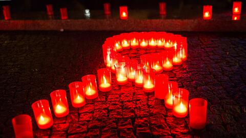 Kerzen bilden eine rote Schleife &ndash; sie ist eines der Symbole für den Kampf gegen Aids.