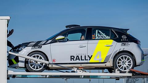 Ein Rallyefahrzeug wird aus einem Lkw ausgeladen.