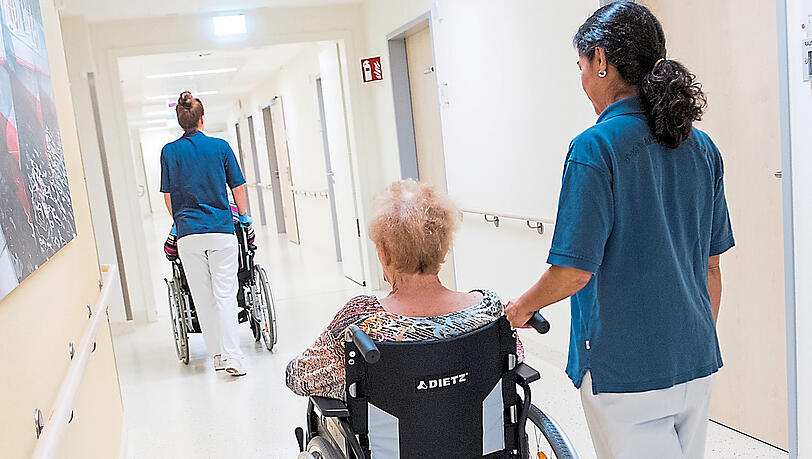 Zwei Schwestern schieben Patienten mit Rollstühlen. Oft beginnt nach der Klinik die Suche nach einem Pflegeplatz. Zwei Schwestern schieben Patienten mit Rollstühlen. Oft beginnt nach der Klinik die Suche nach einem Pflegeplatz.