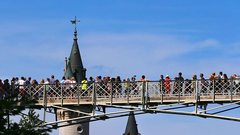Touristen auf der restaurierten Marienbrücke vor Schloss Neuschwanstein.