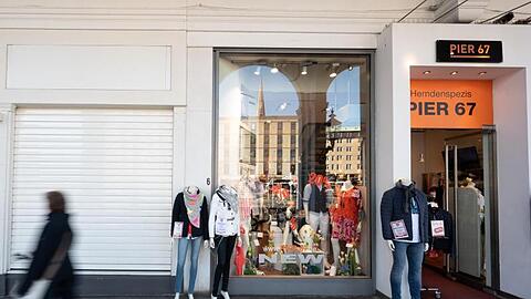 Schaufensterpuppen eines Kleidungsgeschäftes stehen vor einem geöffneten Laden in Hamburg.