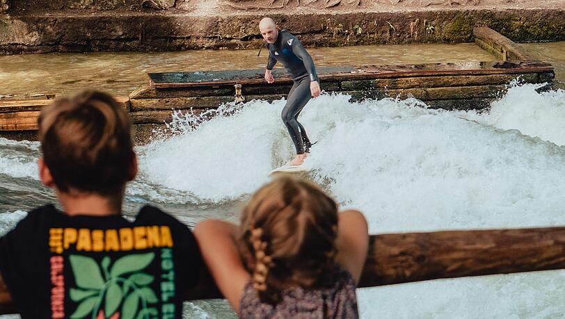 Zwei Kids schauen Zahnarzt Leopold beim Surfen zu. Ohnehin sammeln sich wieder sehr schnell Schaulustige, wenn sich jemand auf die schmale Welle wagt. Zwei Kids schauen Zahnarzt Leopold beim Surfen zu. Ohnehin sammeln sich wieder sehr schnell Schaulustige, wenn sich jemand auf die schmale Welle wagt.