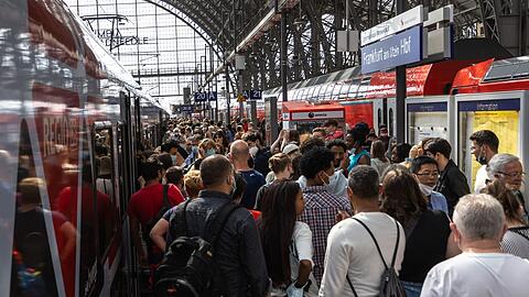 Menschen drängen sich auf einem Gleis im Frankfurter Hauptbahnhof.