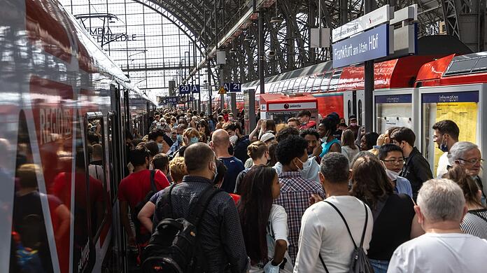Menschen drängen sich auf einem Gleis im Frankfurter Hauptbahnhof.