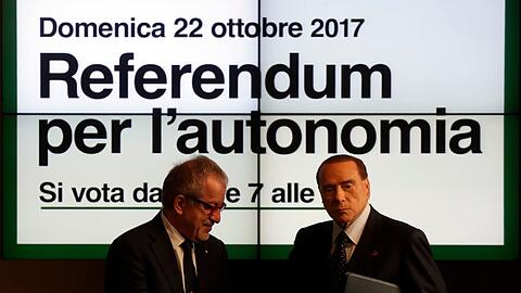 Italiens Ex-Ministerpräsident Silvio Berlusconi und der Präsident der Lombardei Roberto Maroni stehen während einer Pressekonferenz in Mailand zum geplanten Unabhängigkeitsreferendum vor einem Plakat, dass für das Referendum wirbt.