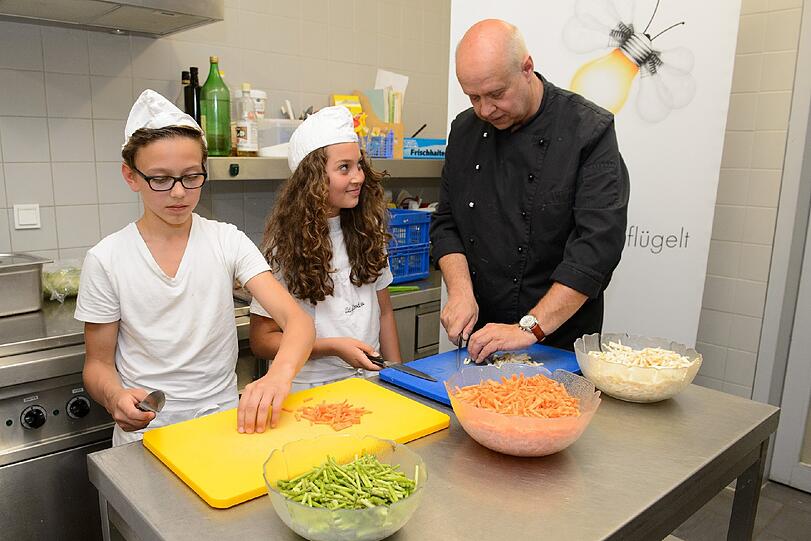 Mensachef Stephan Jäger bereitet mit Schülern des Projekt &bdquo;Pädagogisches Kochen&ldquo; das Mittagessen zu.