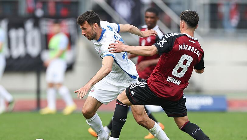 Der Nürnberger Taylan Duman (r) kämpft mit Lukas Fröde von Hansa Rostock um den Ball.