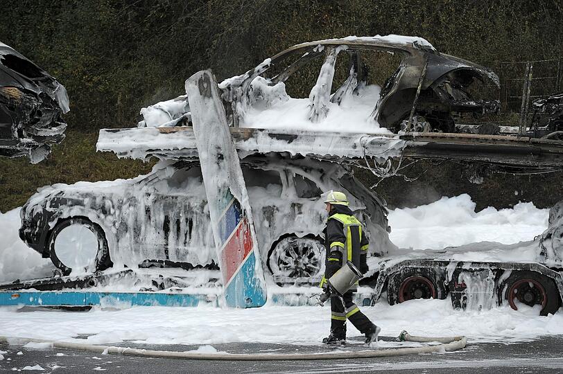 Völlig verbrannt und voller Lösch-Schaum: Auf der A9 bei Bayreuth ist ein Autotransporter in Flammen aufgegangen. Geladen hatte der Lastzug hochwertige Porsche Cayenne und Panamera. Die Bilder.