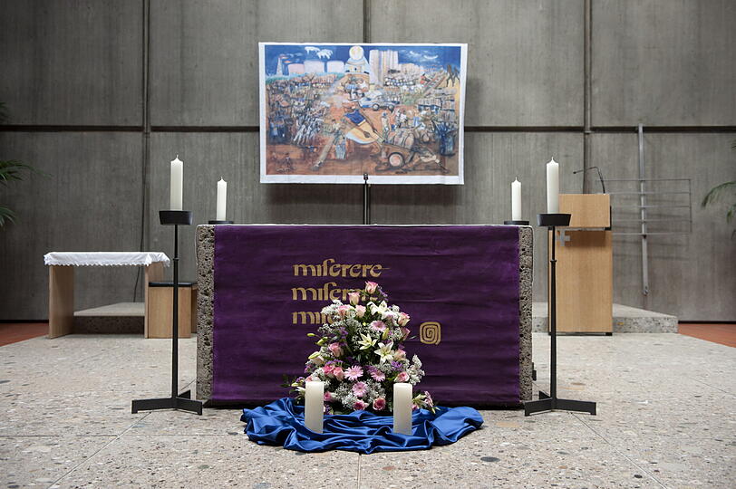 Kerzen und Blumen stehen vor dem Altar.