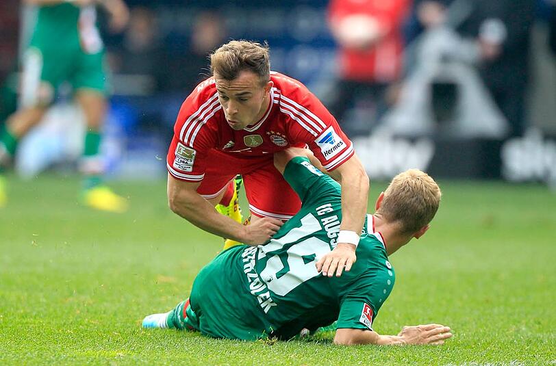 Bayerns Xherdan Shaqiri fliegt über FCA-Spieler Ostrzolek. Der Schweizer konnte nach der Pause nicht weiterspielen.