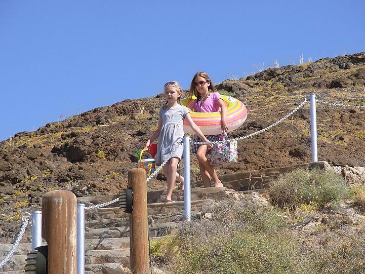 Robinson Club Esquinzo: Mit Badesachen bepackt spazieren die jungen Wasserratten über die Steintreppe hinab zum Sandstrand.