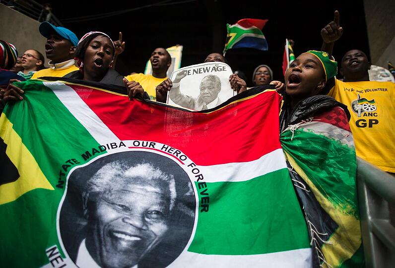 Südafrika verabschiedet sich von Nelson Mandela. Um 14 Uhr MEZ beginnt die gigantische Trauerfeier, die auf 90 Leinwände im Land übertragen wird. So langsam füllen sich die Plätze im Land. Hier die Bilder...