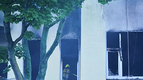 Feuerwehrleute arbeiten mit Atemschutz in der  ausgebrannten Wohnung in Berlin-Wilmersdorf.