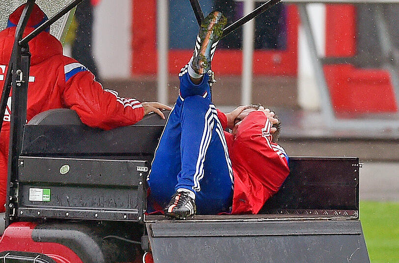 Alleine geht nichts - die Teamkollegen helfen Lahm auf das herbeigerufene Goldcart.