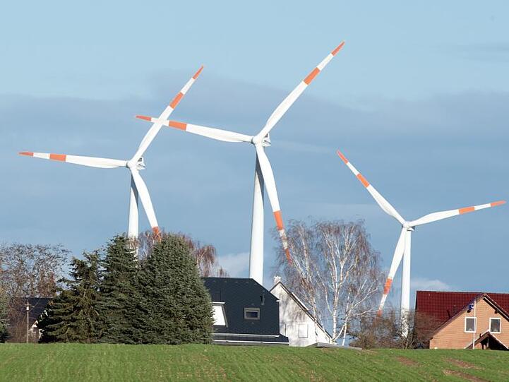 Windräder drehen sich hinter den Häusern von Krummensee im brandenburgischen Landkreis Barnim.